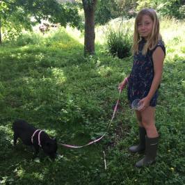 a woman holding a dog in the grass