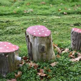 a couple of lawn chairs sitting on top of a grass covered field